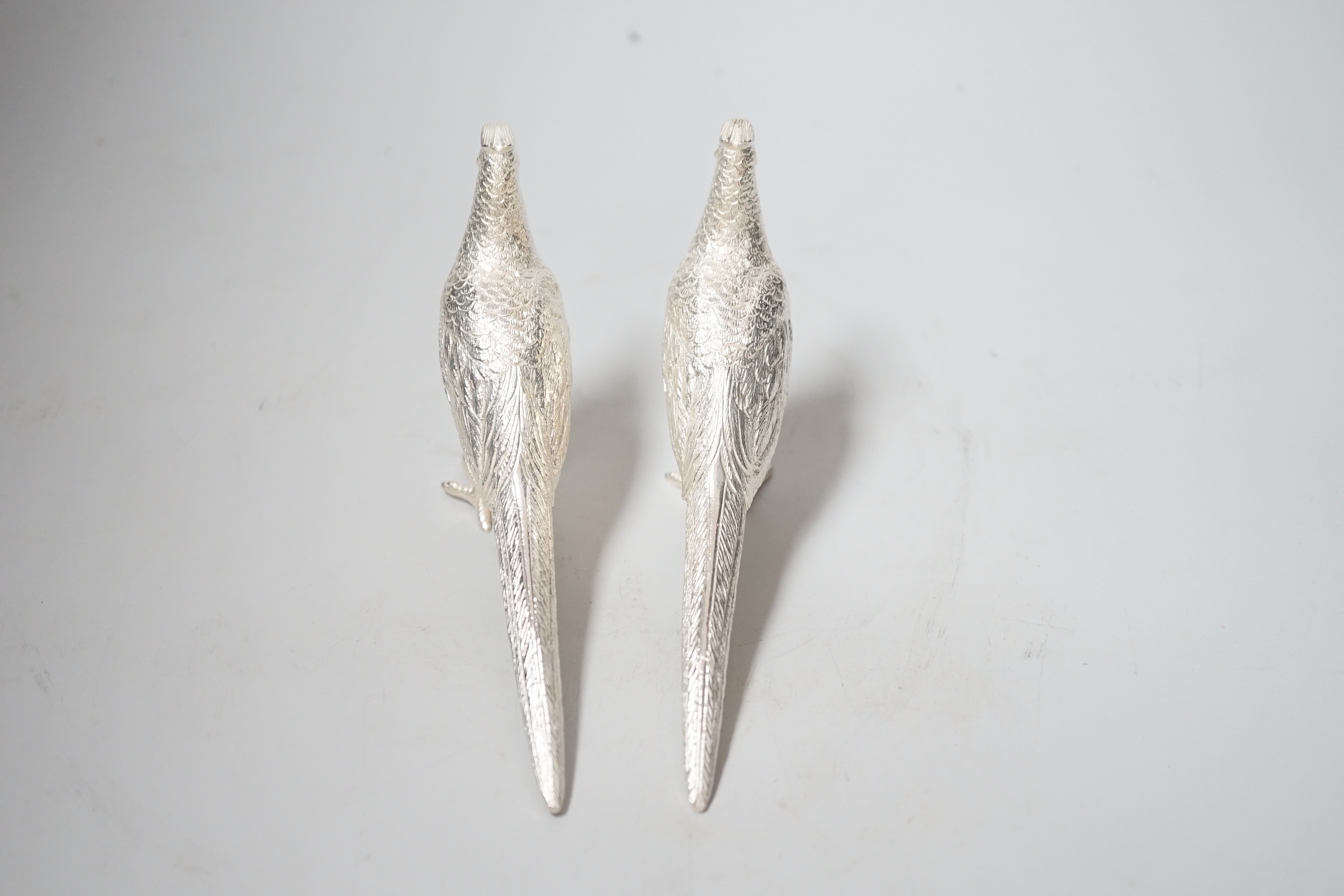 A pair of Elizabeth II silver model free-standing pheasants, by Albert Edward Jones, London, 1973, length 16cm, 9.6oz.